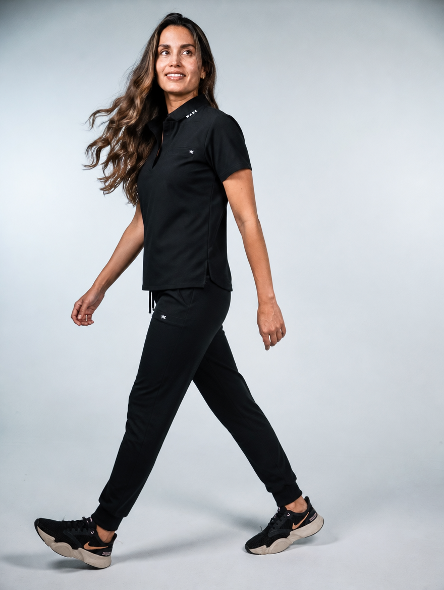 Modelo caminando con el conjunto negro y jogger de Wake Health